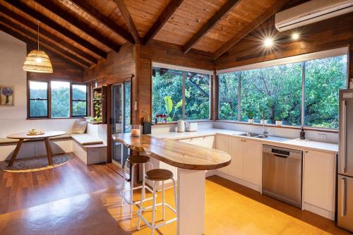 a kitchen with a wooden ceiling and a large window at The Enchanted Stone Cottage in Margaret River Town