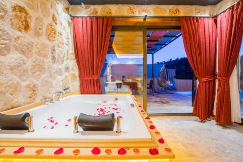 een badkamer met een bad en rode gordijnen bij Villa Vadi Exclusive in Çayköy