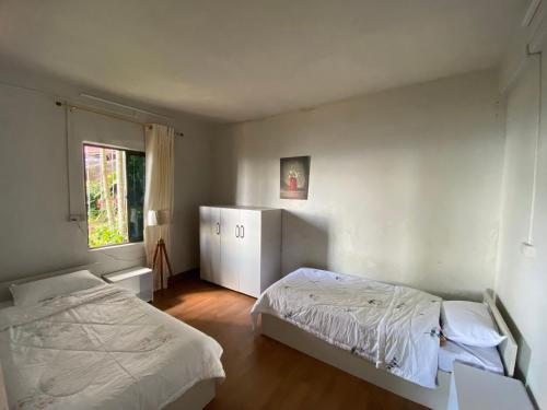 a bedroom with two beds and a window at Wayward Homestay in Āīzawl