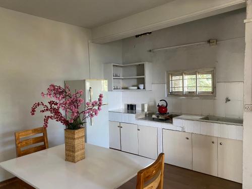 a kitchen with a table with a vase of flowers on it at Wayward Homestay in Āīzawl