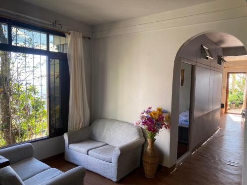 a living room with a couch and a chair and a mirror at Wayward Homestay in Āīzawl