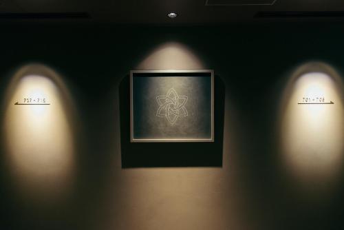 two lights on a wall in a room with a picture at NOHGA HOTEL UENO TOKYO in Tokyo