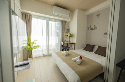 a bedroom with a bed with two stuffed animals on it at Hotel Story Namba in Osaka
