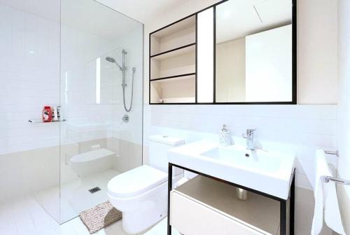 a white bathroom with a toilet and a sink at Brilliant Quay Blvd Apt Close to Wyndham Harbour in Werribee South
