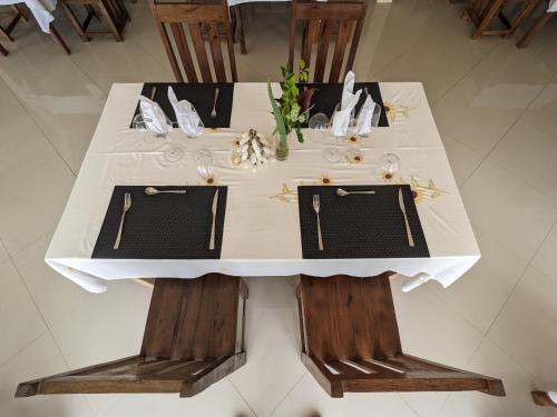 a white table with two chairs and a white table cloth at OKA Forest Lodge in Andasibe