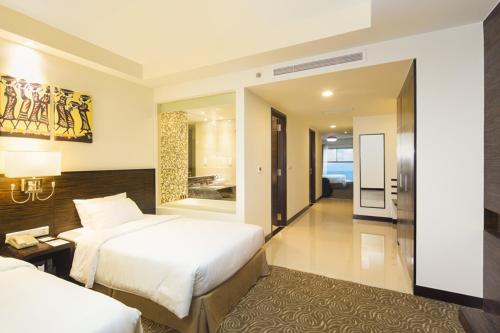 a hotel room with two beds and a bathroom at Havana Nha Trang Hotel in Nha Trang