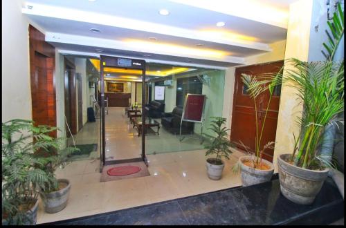 a lobby with potted plants in a building at HOTEL HANUWANT AIRPORT 7 Minutes Distance From IGI AIRPORT 3 Minutes From Aero City Metro Station Book Now For More Offers in New Delhi