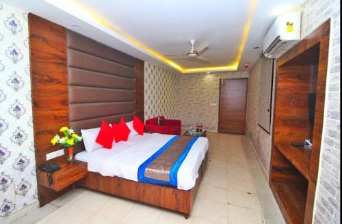 a bedroom with a large bed with red pillows at HOTEL HANUWANT AIRPORT 7 Minutes Distance From IGI AIRPORT 3 Minutes From Aero City Metro Station Book Now For More Offers in New Delhi