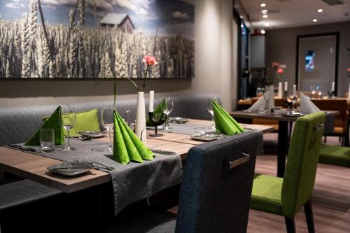 a dining room with a table with green chairs at Spa Hotel Härmä - Härmän Kylpylä in Ylihärmä