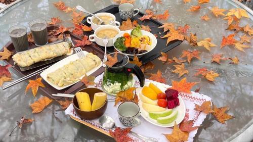una mesa cubierta con comida y fruta encima de las hojas en Rainbow Bridge B&B en Sanzhi