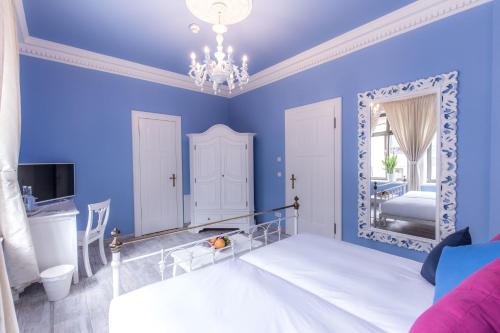 a blue bedroom with a bed and a mirror at Grande Albergo Giancarlo in Weimar