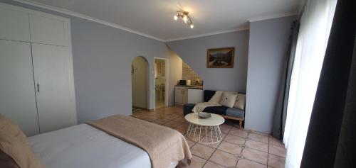 a bedroom with a bed and a table and a couch at Blue Door in Boksburg