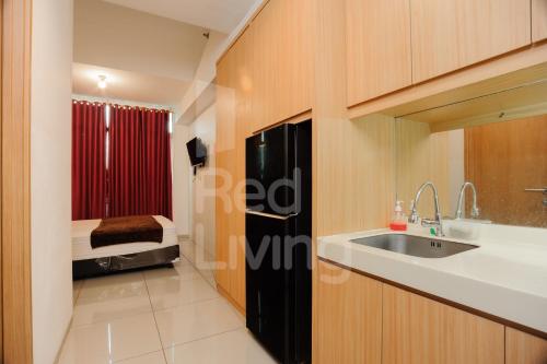 eine kleine Küche mit Spüle und Kühlschrank in der Unterkunft RedLiving Apartemen TreePark City - Hunian Idamanku Tower Alpine in Kebonnanas