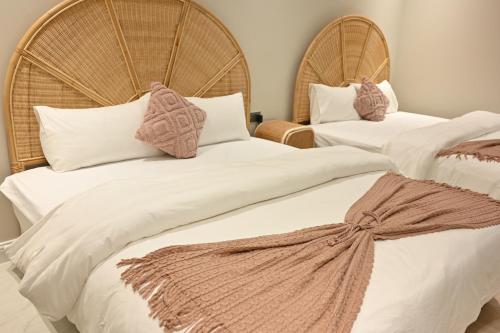 2 camas con sábanas blancas y almohadas marrones en Damas Resort, en Mezairaa