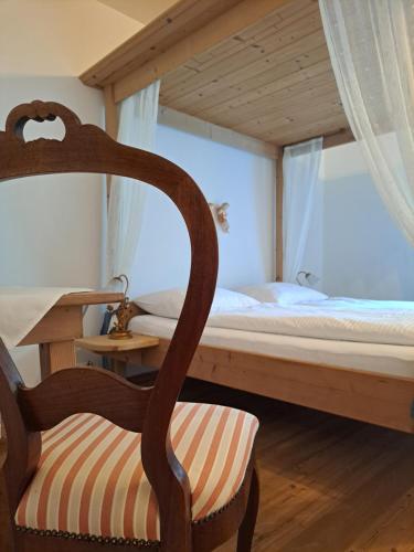 ein Schlafzimmer mit einem Etagenbett und einem Stuhl in der Unterkunft Stauders Zimmer und Ferienwohnungen in Innsbruck