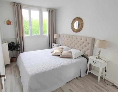 - une chambre blanche avec un lit blanc et un miroir dans l'établissement Bel appartement entre Disney Land et Paris, à Chelles