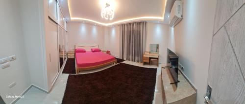 a bedroom with a pink bed in a room at برج حورس in Obour