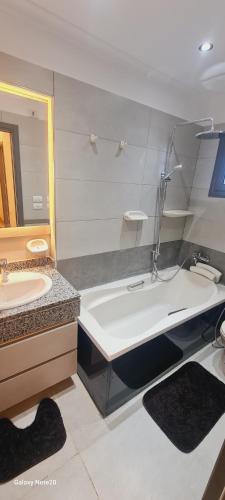 a bathroom with a tub and a sink and a bath tub at برج حورس in Obour