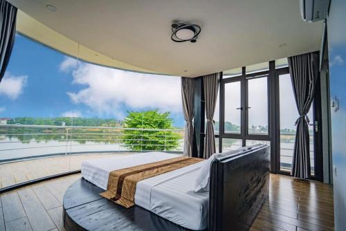 a bedroom with a bed and a large window at DC AROMA VILLA - Venuestay in Hòa Bình