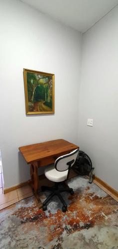 a desk with a chair and a picture on the wall at Blue Door in Boksburg