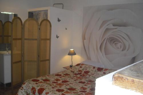 - une chambre avec un lit doté d'un couvre-lit blanc dans l'établissement Le Rosier, à Gordes