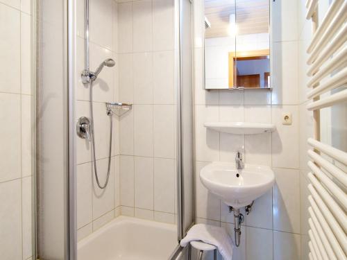 a white bathroom with a shower and a sink at Landhaus am Kienberg in Pfronten