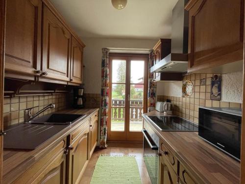 a kitchen with wooden cabinets and a sink and a window at Ferienwohnung Schmuck Eva in Bergen