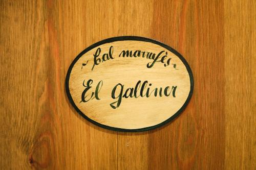 a sign on a wooden door with the words ball monkey elf gallagher at Cal Marrufès in Puigcerdà