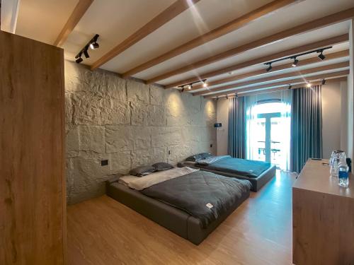 - une chambre avec 2 lits et un mur en pierre dans l'établissement Zeus Living - City Central, à Hô-Chi-Minh-Ville