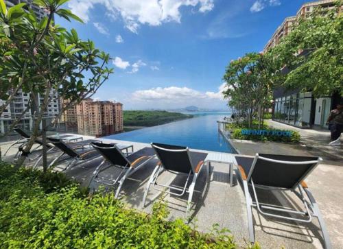 a group of chairs sitting next to a river at Urban Suites, Best Seaview and Cityview in Town in Jelutong