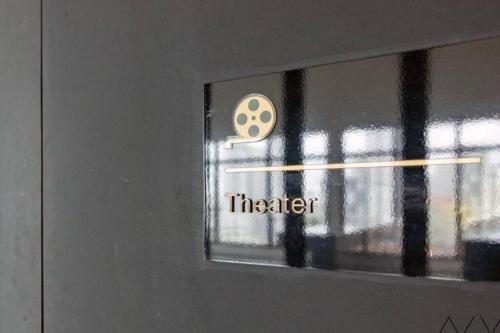 a door with a sign that says theater on it at Urban Suites, Best Seaview and Cityview in Town in Jelutong
