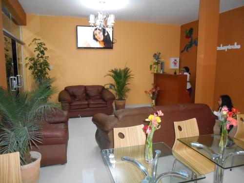 uma sala de estar com mobiliário de couro e uma televisão em USGAR Machupicchu Boutique em Machu Picchu