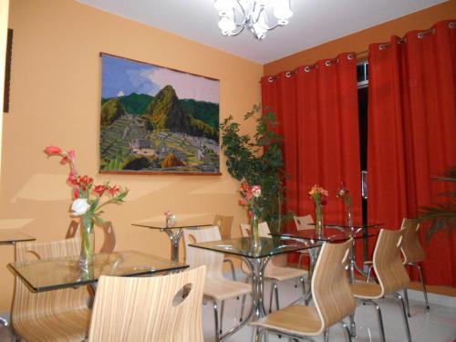 a dining room with tables and chairs and a painting at USGAR Machupicchu Boutique in Machu Picchu