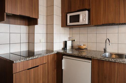 a kitchen with a sink and a microwave at Cal Marrufès in Puigcerdà