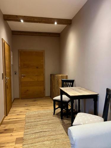Zimmer mit einem Tisch, einem Stuhl und einer Tür in der Unterkunft Zimmer in Kirchberg in Tirol in Kirchberg in Tirol