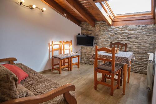a room with a bedroom with a table and chairs at Cal Marrufès in Puigcerdà