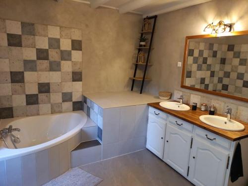 a bathroom with a tub and two sinks and a bath tub at Maison Chez Jeannot in Saint-Geneys-près-Saint-Paulien