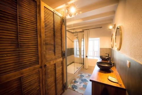 La salle de bains est pourvue d'un lavabo, d'un miroir et d'une douche. dans l'établissement Maison Chez Jeannot, à Saint-Geneys-près-Saint-Paulien