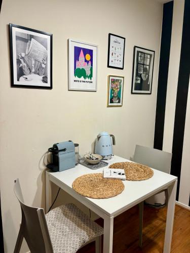 - une table à manger avec une table et des chaises blanches dans l'établissement Fleure de Ly / Superb studio flat in Old Town, à Metz