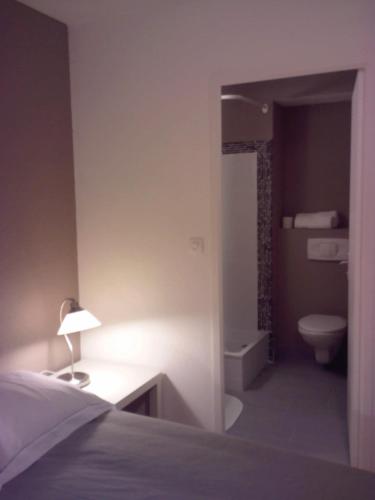 een slaapkamer met een bed en een badkamer met een toilet bij Studio Brest Centre ville Jean Jaurès in Brest