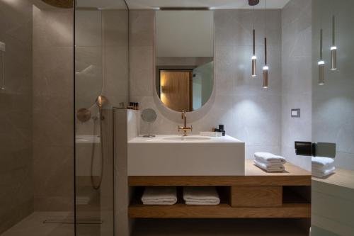 a bathroom with a sink and a mirror at Oniro Boutique Hotel in Toroni