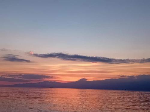 een zonsondergang boven een lichaam van water met de hemel bij IGGY in Malinska