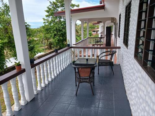 a porch with two chairs and a table at Olosara Haven in Nayawa