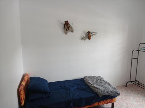 twee vlinders aan de muur boven een bed bij Olosara Haven in Nayawa
