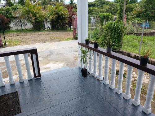 a porch with potted plants on a white railing at Olosara Haven in Nayawa