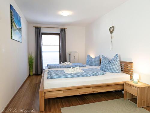 a bedroom with two beds with blue and white pillows at Fewo Am Mühlbach 5 AMB5 in Mittenwald