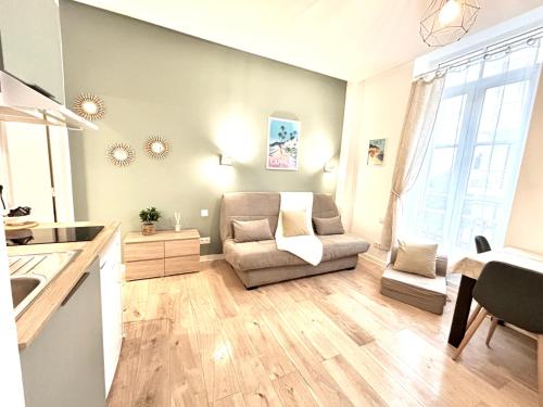 ein Wohnzimmer mit einem Sofa und einer Küche in der Unterkunft Studio center 104 in Cannes