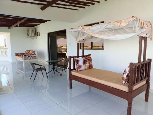 a bedroom with a bunk bed and a table and chairs at Villa Becky - Diani Beach in Diani Beach