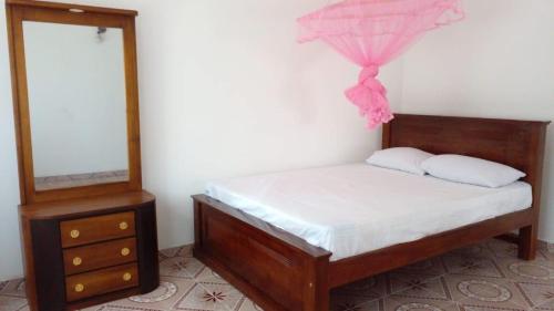 1 dormitorio con 1 cama con tocador y espejo en Ramya Villa, en Galle
