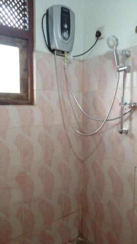 y baño con ducha y secador de pelo en la pared. en Ramya Villa, en Galle